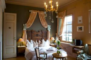 - une chambre avec un lit et un lustre dans l'établissement Dépendance Maison Géron, à Malmedy