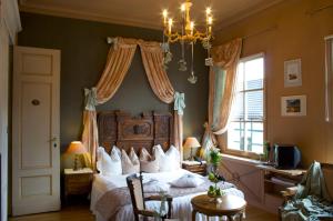 a bedroom with a bed and a chandelier at Dépendance Maison Géron in Malmedy