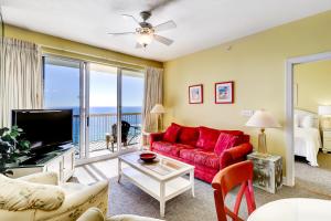 a living room with a red couch and a tv at Sunrise Beach Resort II in Panama City Beach