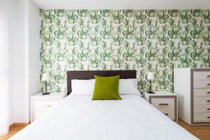 een slaapkamer met een bed met een groene accentmuur bij RK Atlantis Vacational in Las Palmas de Gran Canaria