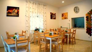 a dining room with tables and chairs and a clock at La Lanterna Sul Comò in Civitavecchia