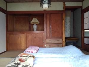 a bedroom with a bed with a wooden headboard at Akiu Canada 鴻の巣温泉 Konosu Onsen in Sendai