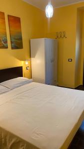 uma grande cama branca num quarto com paredes amarelas em Alloggio turistico em Capodimonte