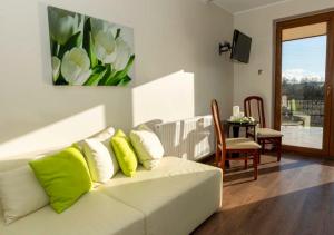 a living room with a white couch with green pillows at Dom Grinholc in Rumia
