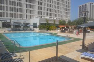a large swimming pool in the middle of a city at Golden Tulip Bahrain in Manama