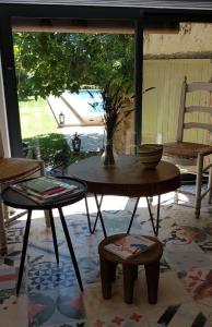 un patio con 2 mesas, sillas y un jarrón en La Melizanne, en Fuveau