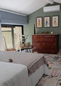 a bedroom with a bed and a wooden dresser at La Melizanne in Fuveau