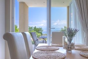 a table with pillows and chairs with a view of the ocean at Luxury Apartments Villa Luce in Malinska