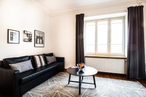 een woonkamer met een zwarte bank en een tafel bij Powiśle Superior Apartment in Warschau