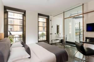 a bedroom with a bed and a desk and windows at Hotel Royal Bissolati in Rome