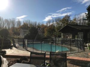 una piscina con una valla alrededor en Les Genets, en Orléat