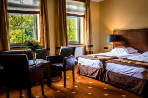 a hotel room with two beds and a table and chairs at Hotel Nowy Dwór Elizy blisko Sky Bridge in Długopole-Zdrój +47 photos