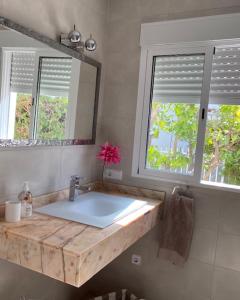 a bathroom with a sink and a mirror and two windows at Peralba in Alcudia