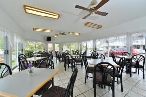 un comedor con mesas, sillas y ventanas en Americas Best Value Inn Mackinaw City en Mackinaw City