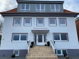 a white house with a staircase in front of it at Meeresrauschen in Dahme