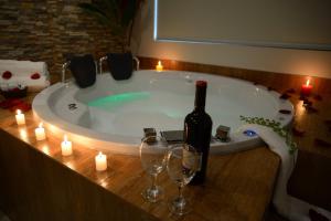 een fles wijn en wijnglazen in een bad bij Hotel Monte Cafeto INN in Pichanaki