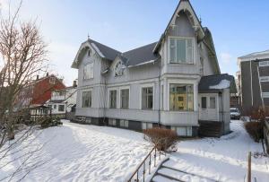 una casa grande con nieve delante en Sudurgata - Authentic Reykjavik Style Apartment en Reikiavik