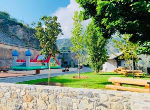 um parque com bancos e uma parede de pedra em Stella Alpina em Rimplas