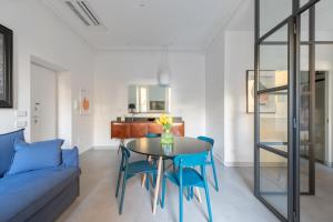 a living room with a blue couch and a table and chairs at Twin Flowers apartment in San Giovanni in Rome