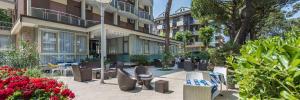 a courtyard with chairs and tables in front of a building at Hotel Palladio B&B in Cervia