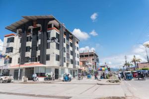 a building on a city street with people standing outside at Hotel Monte Cafeto INN in Pichanaki