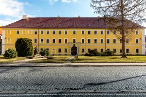 um grande edifício amarelo com um telhado vermelho em Ubytování 8 em Jaroměř