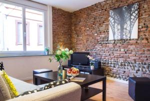 uma sala de estar com uma parede de tijolos em Rosa Bonheur by Cocoonr em Toulouse