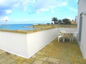 d'un balcon avec une table et des chaises donnant sur l'océan. dans l'établissement Casa vacanze frida a Otranto centro, Salento, mono 2/3 posti, à Otrante