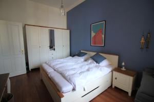 a bedroom with a large bed with a blue wall at Villa Hintze Wohnung 9 in Heringsdorf