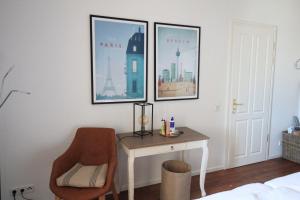 a bedroom with a desk and a chair and two pictures at Villa Hintze Wohnung 9 in Heringsdorf