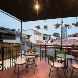 a patio with tables and chairs on a balcony at Attic Hotel in George Town