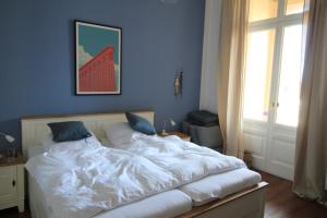 Villa Hintze Wohnung 9 في هيرينجسدورف: غرفة نوم بسرير وملاءات بيضاء ونافذة