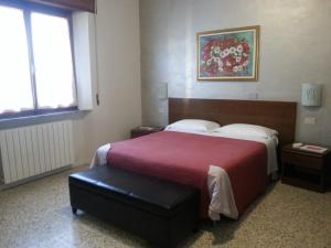 Habitación de hotel con cama grande con manta roja en Hotel Pensione Signorini, en Castiglioncello