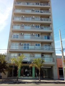 a tall white building with trees in front of it at Departamento nuevo y luminoso en el centro. in La Rioja