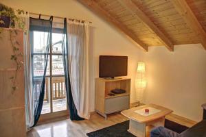 een woonkamer met een tv en een groot raam bij Ferienwohnung Petra in Bischofsmais