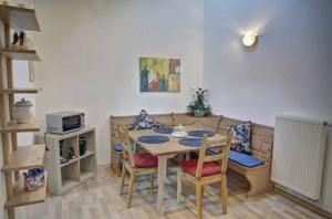 a dining room with a table and chairs and a couch at Ferienwohnung Petra in Bischofsmais