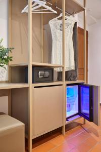 a wardrobe with a dress and a tv in it at Sette Angeli Rooms in Florence