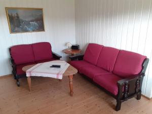 a living room with a purple couch and a table at Skudenes Camping in Skudeneshavn