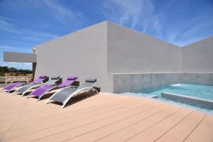 un grupo de sillas sentadas en una terraza junto a una piscina en Casa Lou, architect villa with heated pool at Begur, 470m2, en Begur