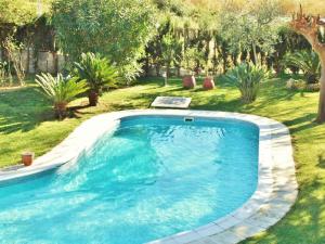 a large swimming pool in a yard with plants at Belvilla by OYO Casa Jaume in San Pol de Mar