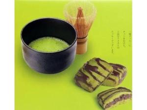 un tazón negro y algunas galletas en una mesa verde en Ryugu Hotel en Nishio