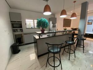 a kitchen with a bar with stools and a counter top at Liberdada Villa SURINAME in Wanica