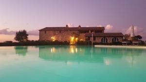 a large pool of water in front of a building at Casanova di Neri Relais in Montalcino