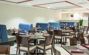 uma sala de jantar com mesas e cadeiras e cabinas azuis em Holiday Inn Oceanside Marina Camp Pendleton, an IHG Hotel em Oceanside