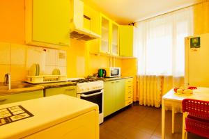 モスクワにあるKvartiraSvobodna - Apartments Rublevskoe shosse 5のキッチン(黄色のキャビネット、コンロ付)