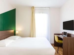 Postel nebo postele na pokoji v ubytování Aparthotel Adagio Access Carrières Sous Poissy