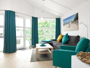 - un salon avec un canapé et une table dans l'établissement Dänische Ferienhäuser am Salzhaff Haus Im Wiesengrund, à Poel