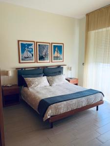 a bedroom with a bed with four pictures on the wall at Maison Belle Vue in Chioggia