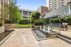 a courtyard with a fountain in the middle of a building at Central Melbourne CBD Apartment with Gym and Pool in Melbourne