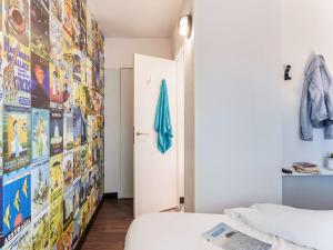 um quarto com uma cama e uma parede com cartazes em HôtelF1 Angoulême em Champniers